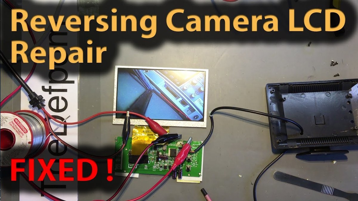 Person inspecting a flickering backup camera display in a parked car to diagnose the issue before replacing parts.