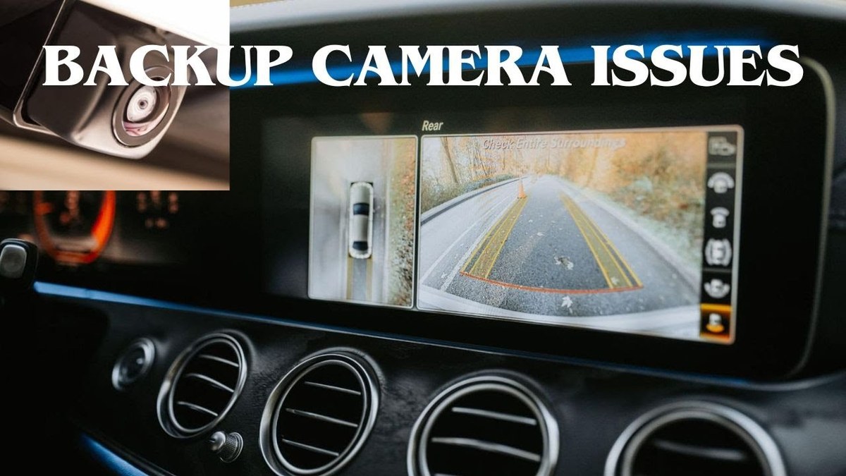 Close-up of a car backup camera lens partially covered with ice and snow on a cold winter day.
