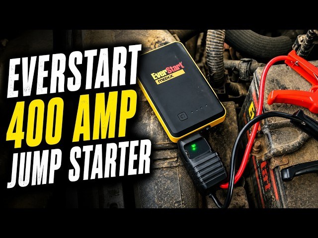 A jump starter clamped to a car battery showing correct polarity and voltage settings to prevent beeping.