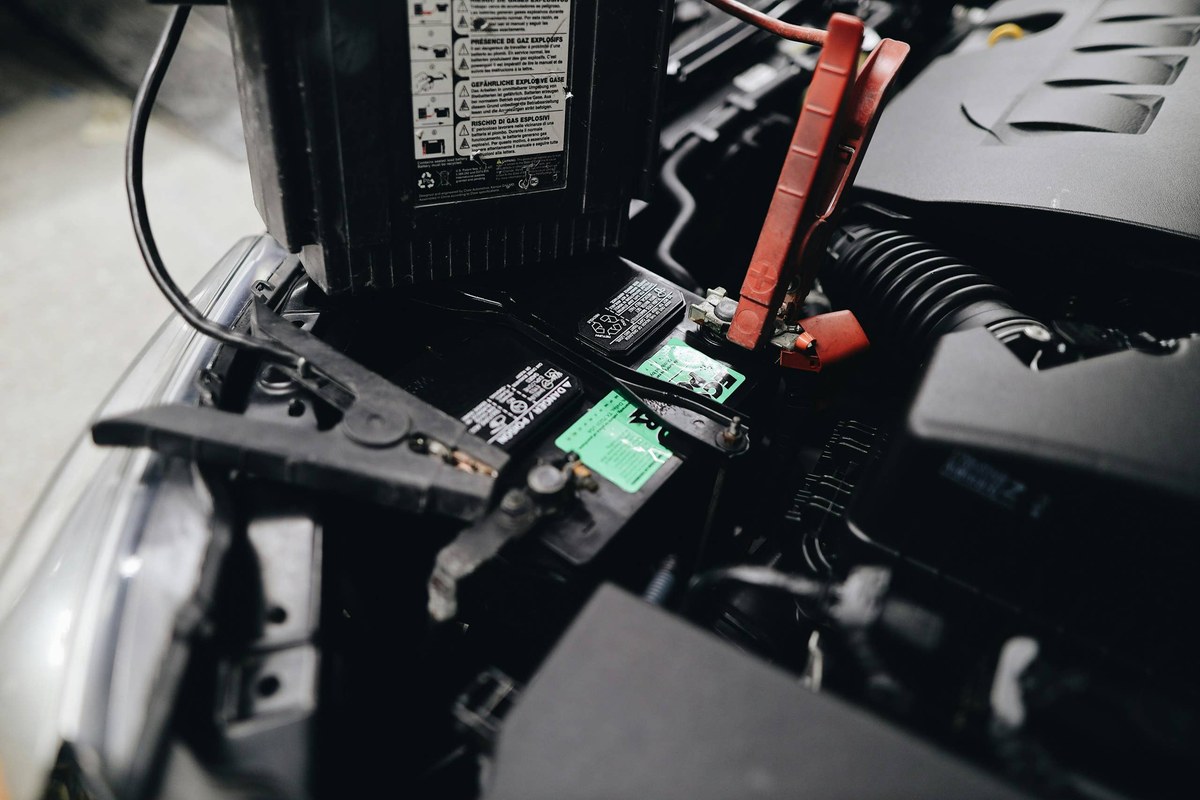 Close-up of corroded battery clamps on a jump starter cable showing signs of overheating.