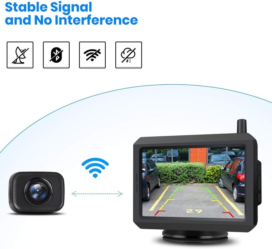 Technician troubleshooting a wireless backup camera with antenna and monitor displaying interference static.